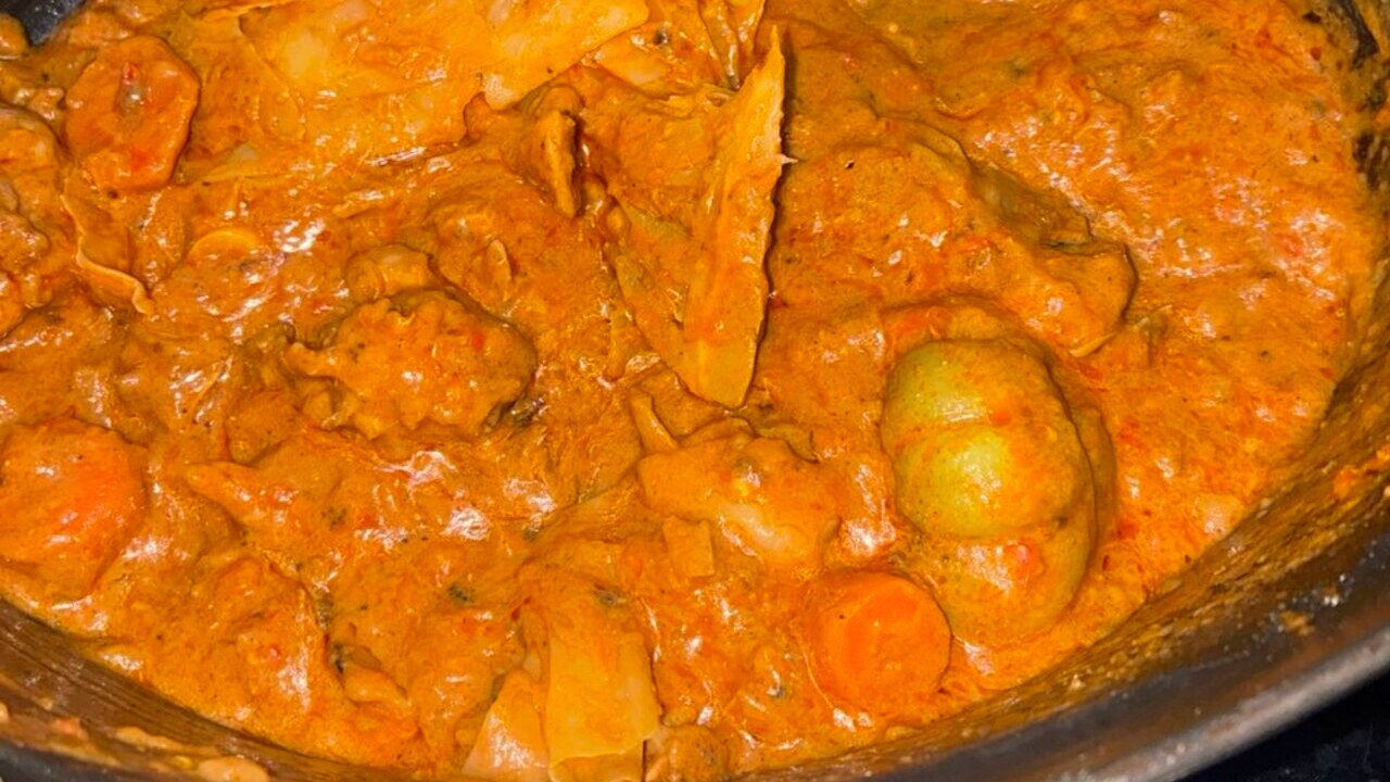 Traditional Malian peanut butter stew with meat and vegetables in a cooking pot